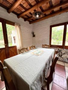 拉库布蕾Cabañas Lomita San Luis的一间设有白色桌子、椅子和窗户的用餐室