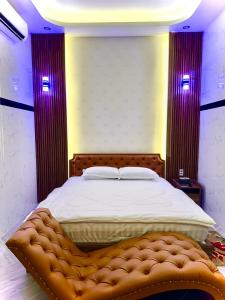 Cao LãnhBảo Ngọc Hotel的一间卧室配有一张大床和一张带软木脚板的