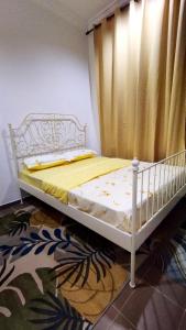 Kampong Ru SepulohRUMAH PANTAI HOMESTAY的配有窗帘的客房内的一张白色床