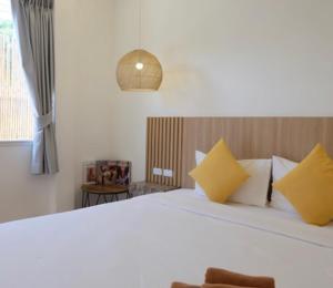 格兰岛Thandara kohlarn的卧室配有一张带黄色枕头的大型白色床。