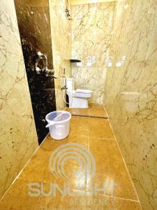 钦奈Sunlight Residency的浴室设有卫生间和一个带标志的台面