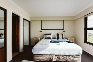 新普利茅斯ABC On Wanaka Bay Support Local的一间卧室设有一张大床和一个窗户。