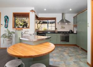 新普利茅斯Beachfront Bliss On Wanaka Terrace Support Local的厨房配有水槽和木桌