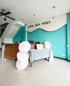 卡塔海滩Kata Sea Host的一间设有一张床和两把白色遮阳伞的房间