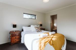 新普利茅斯Seven By The Sea Tourist Hot Spot的卧室设有一张白色大床和一扇窗户。