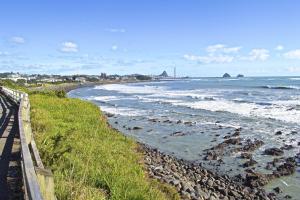 新普利茅斯Escape To Buller Prime Holiday Location的一个带栅栏的海滩和大海