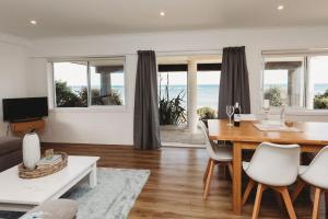 新普利茅斯Wow On Wanaka Bay的客厅设有餐桌,享有海景