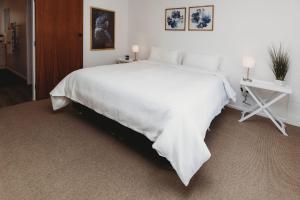 新普利茅斯Wow On Wanaka Bay的一张白色的大床,上面有白色的毯子