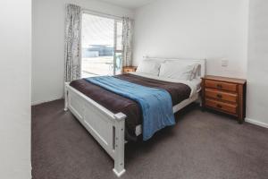新普利茅斯Holiday On Hamblyn的卧室配有白色的床和窗户。