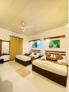 阿努拉德普勒Sadula Holiday Resort的一间卧室,配有三张床