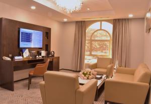 巴哈Cloud City Hotel فندق مدينة السحاب的客厅配有桌椅和电视。