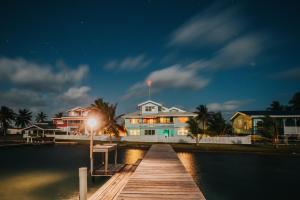 伯利兹城Casa Al Mar, St. George's Caye - Belize的夜间水面上的房子