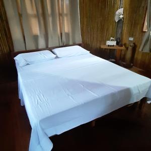 杜马格特Dumaguete Treehouse的一张带白色床单和枕头的床