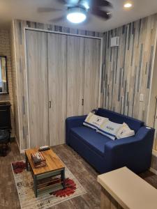 志摩市Seaside Garage Shima - Vacation STAY 77073v的客厅配有蓝色的沙发和桌子