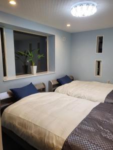 志摩市Seaside Garage Shima - Vacation STAY 77073v的一间卧室设有两张床和一个带盆子的窗户。