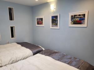 志摩市Seaside Garage Shima - Vacation STAY 77073v的卧室配有两张床,墙上挂有图片