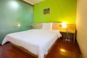 北京7天连锁酒店北京上地店的卧室配有白色的床和绿色的墙壁