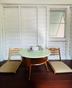 Klong ToiThe Backyard 28的一个带两扇窗户的房间,配有一张桌子和椅子