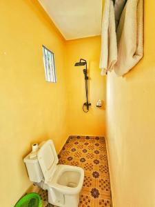 RubiriziLights of kazinga orphanage and homestay的黄色的浴室设有卫生间和淋浴。