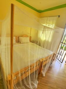 RubiriziLights of kazinga orphanage and homestay的一间卧室配有一张带蚊帐的床