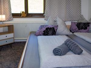维尔德科格尔山麓布兰贝格丹克尔公寓的一间卧室配有一张带紫色枕头的大床