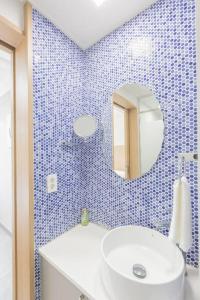 西归浦市TamnaCounty L101 - DtreeSuite OceanVIew,B&B,BBQ,Pool的蓝色瓷砖浴室设有水槽和镜子