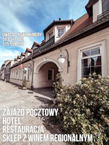 绿山城Hotel Zajazd Kultury, dawniej Pocztowy的前面有标志的建筑
