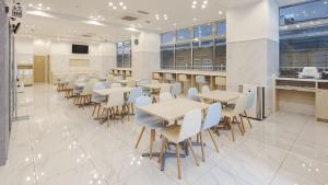 周南市Toyoko Inn Tokuyama-eki Kita-guchi的自助餐厅内带桌椅的用餐区