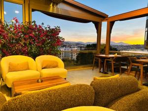 库萨达斯MONALİSA HOTELS的一间配备有黄色家具的起居室,享有城市美景。