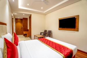 班加罗尔FabHotel Phoenix Horamavu的配有一张床和一台平面电视的酒店客房