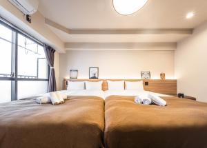 大阪轻宿心斋桥4号店的一间卧室配有一张大床和两个枕头