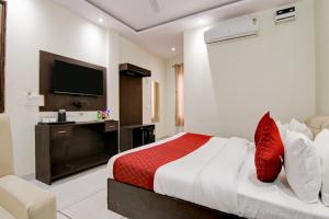 新德里Hotel De Hocks Deluxe - New Delhi的酒店客房,配有床和电视