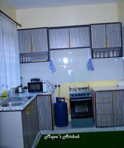 NyahururuMupa's Luxury Condo II的厨房配有水槽和炉灶 顶部烤箱