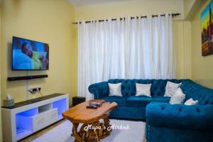 NyahururuMupa's Luxury Condo II的客厅配有蓝色的沙发和桌子