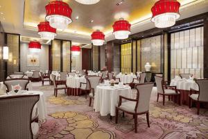 宁德宁德富力万达嘉华酒店的用餐室配有桌椅和吊灯。