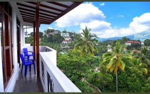 康提SaRu Holiday Apartment - Upto 6 Guests的阳台设有蓝色椅子,享有城市美景。