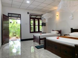 锡吉里亚Manju Homestay的一间卧室设有两张床和窗户。