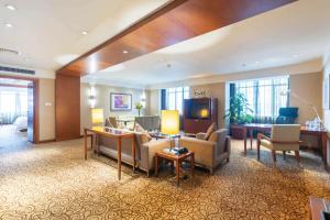 重庆重庆解放碑帝晶酒店的一间客厅,客厅配有沙发和电视,位于酒店的房间