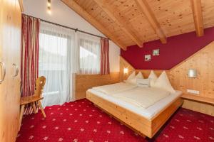 斯拉德明Gästehaus Sieder by Schladming-Appartements的一间卧室配有一张床,铺有红色地毯