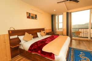达兰萨拉Himalayan Suite的一间带大床的卧室和一个阳台