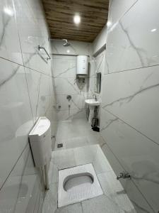 斯利那加Aasariya Hotel And Restaurants的白色的浴室设有卫生间和水槽。