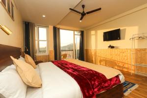 达兰萨拉Himalayan Suite的一间卧室配有一张床铺,床上铺有红色毯子