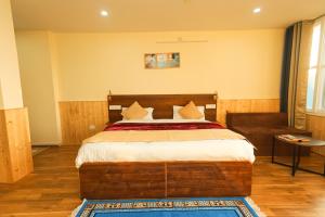 达兰萨拉Himalayan Suite的一间卧室配有一张大床和一张沙发