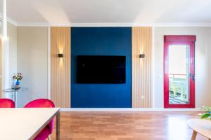 马拉加Ubicación Perfecta Apartamento Luxury Beach的客厅设有蓝色墙壁和平面电视。