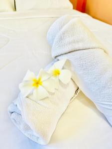 Tha KradanSuriyan Villa Erawan Kanchanaburi สุริยัน วิลล่า เอราวัณ กาญจนบุรี的床上的白色毛巾,两朵白色鲜花