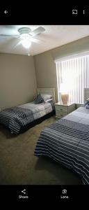基西米Florida Villa的一间卧室设有两张床和一个带风扇的窗户。