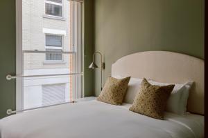 伦敦Native Kings Wardrobe的卧室配有白色的床和窗户。