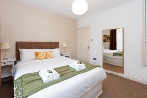 伦敦Beautiful 2BR Flat, Peaceful Dulwich, South London的卧室配有带毛巾的大型白色床