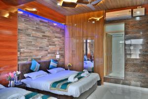 斯利那加Aasariya Hotel And Restaurants的一间卧室设有两张床和砖墙