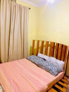 Sanya JuuUkali ukalini homes的卧室内的一张带木制床头板的床